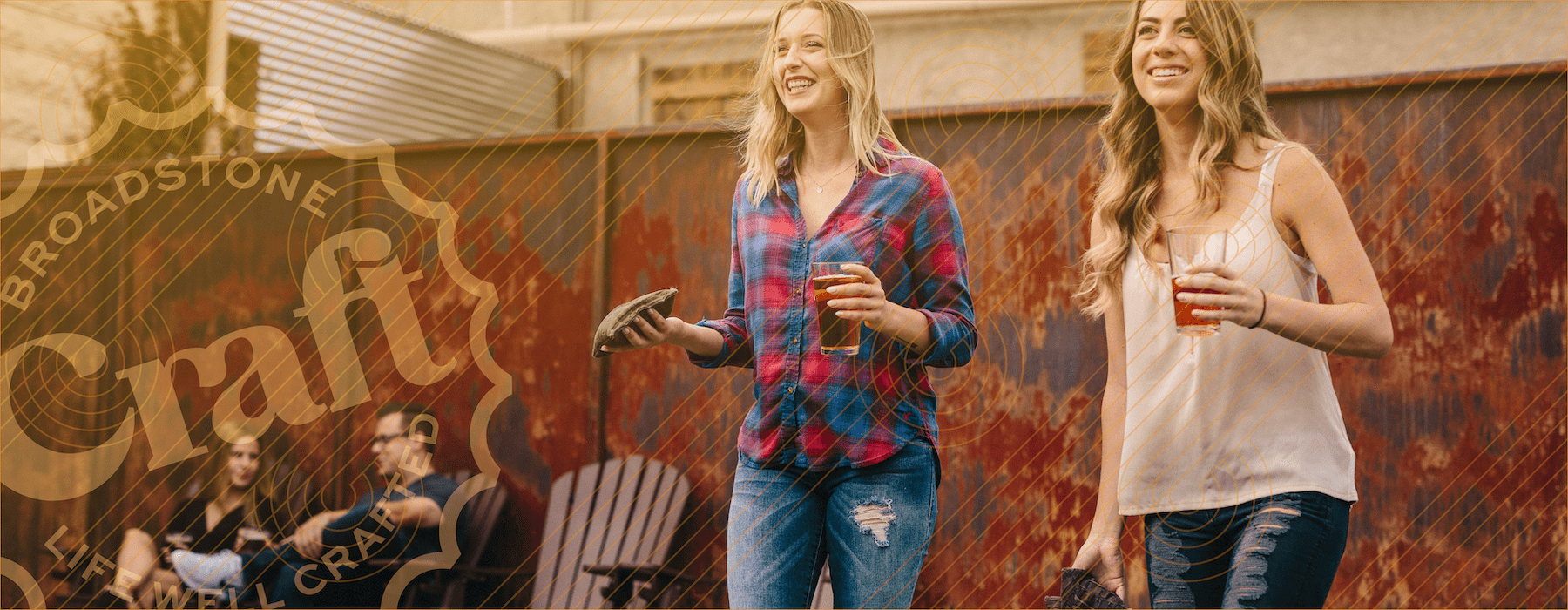 lifestyle image of two women smiling with beers in their hand